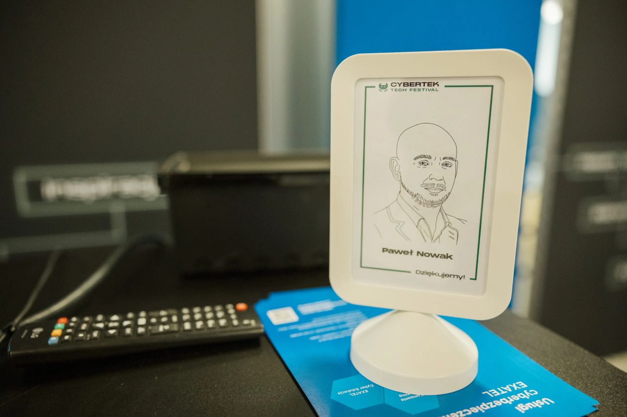 Rysunkowy portret prelegenta w ramce jako pamiątka z CyberTek Tech Festival